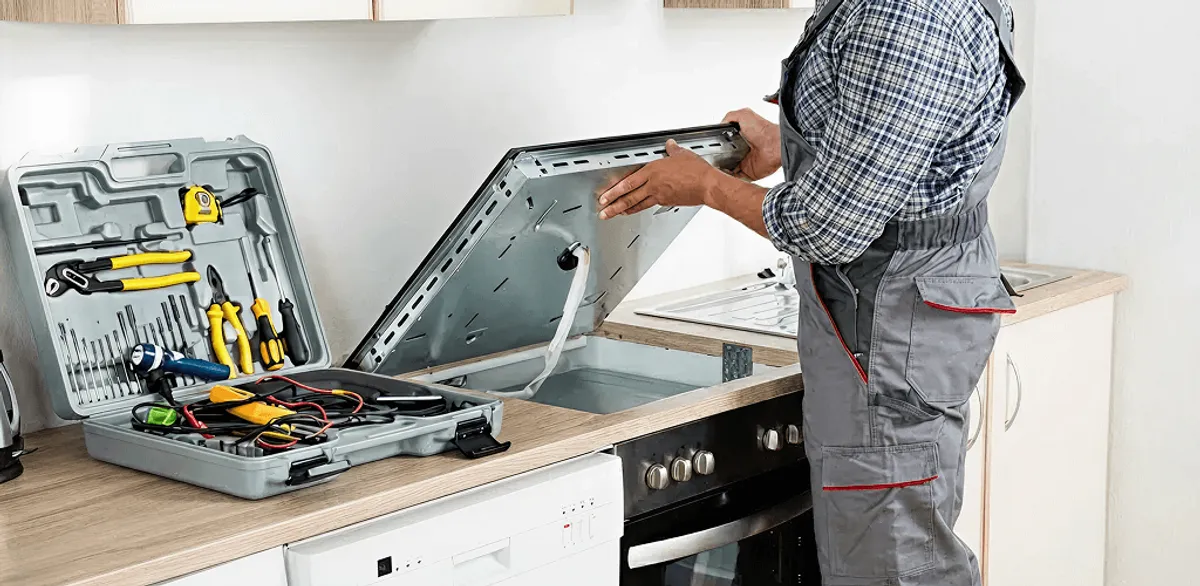 Handyman repairing a cooktop and checking wiring connections in San Diego, CA